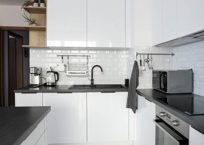 Modern fehér konyhabútor fekete pulttal